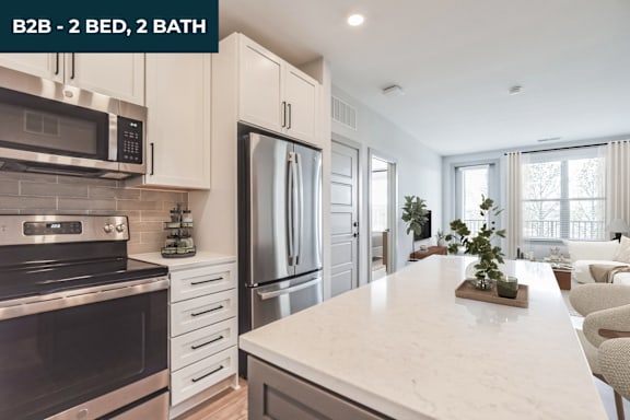 A modern kitchen with a marble countertop and stainless steel appliances.