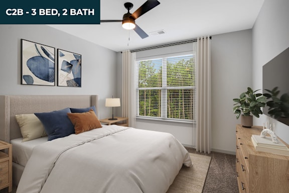 A bedroom with a bed, two lamps, and a ceiling fan.