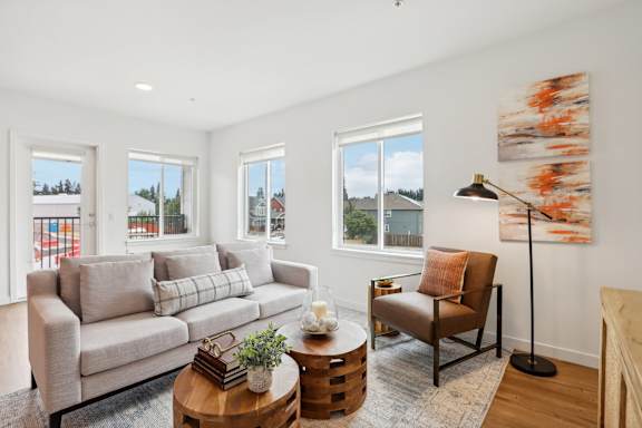 a living room with a couch and a coffee table and windows