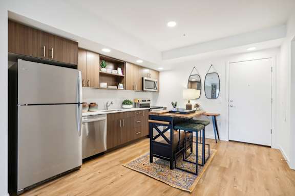 a kitchen with stainless steel appliances and a dining room table