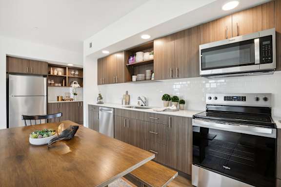 a kitchen with stainless steel appliances and a wooden table