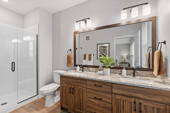 A bathroom with a toilet, sink, and mirror.