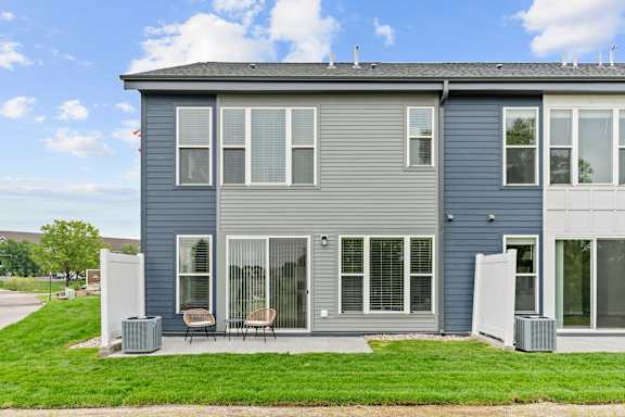 A grey house with a white door and windows.