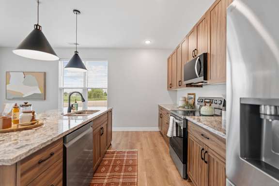 A kitchen with wooden cabinets and a granite countertop.