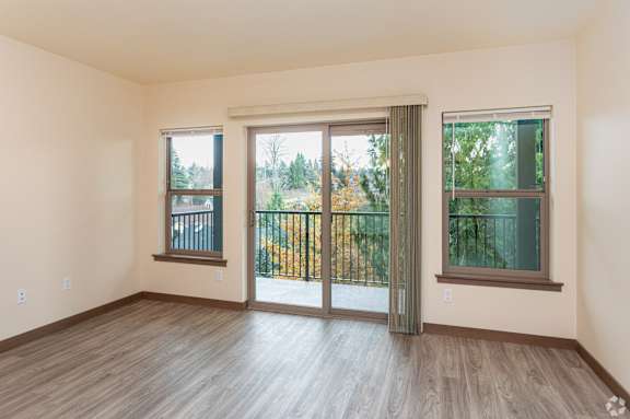 A room with a sliding glass door and a wooden floor.