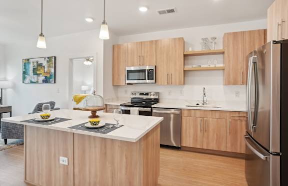 A modern kitchen with wooden cabinets and stainless steel appliances.