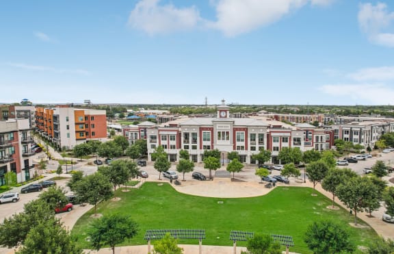 an aerial view of a campus with buildings and a green field
