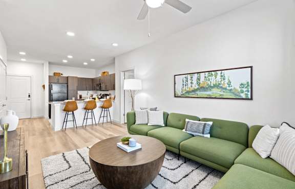 a living room with a green couch and a round coffee table