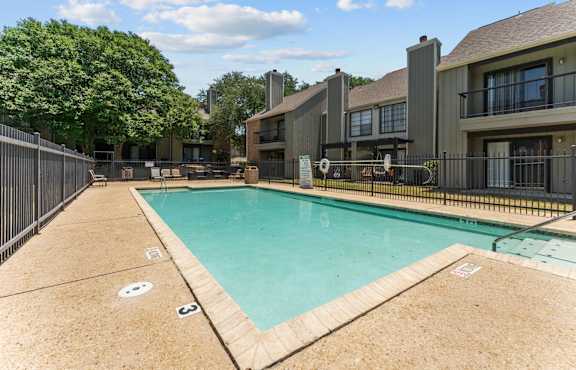 a swimming pool with a fountain    in front of a building