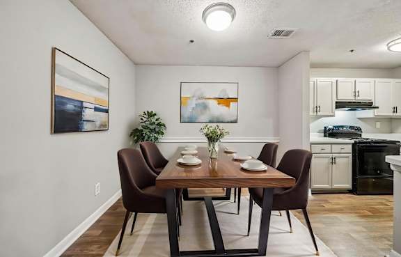 A dining room with a wooden table and brown chairs.