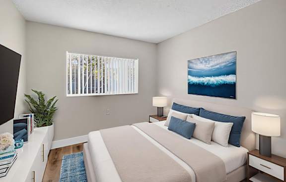 A bedroom with a large bed and a painting of a wave on the wall.