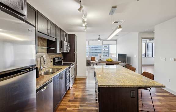 A modern kitchen with dark wood cabinets and stainless steel appliances.
