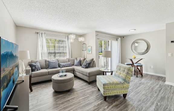 A living room with a sofa, a chair, and a painting on the wall.