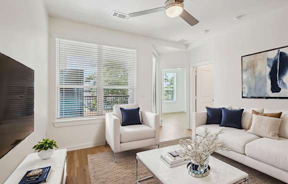 Three people sitting on a couch in a living room.
