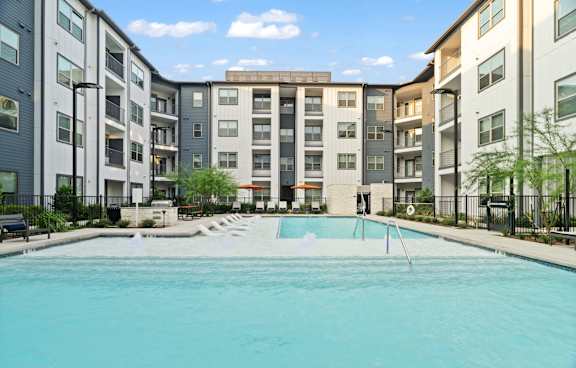 A swimming pool in front of apartment buildings.