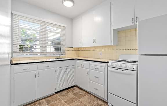 a kitchen with white cabinets and white appliances