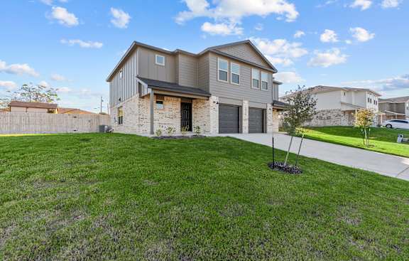 a house with a driveway and a lawn in front of it