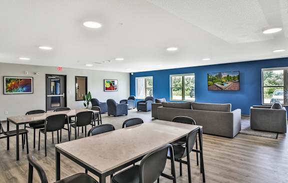 A room with tables and chairs and a blue wall.