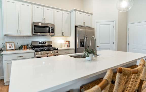 a view of a kitchen with a island and blue chairs