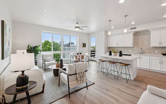 A spacious kitchen with white cabinets and a large window.