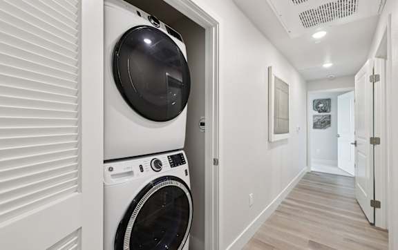 A white bathroom with a toilet, sink, and shower.