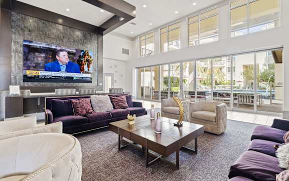 A modern living room with a purple couch and a flat screen TV.