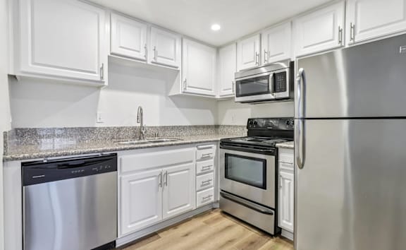 A kitchen with white cabinets and stainless steel appliances.