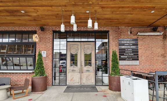 The entrance to a building with a wooden ceiling and a brick wall.