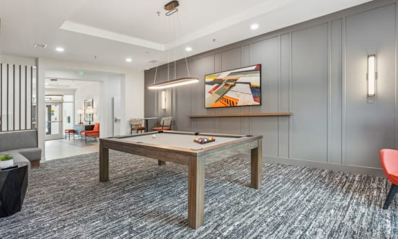 a rec room with a pool table and a painting on the wall