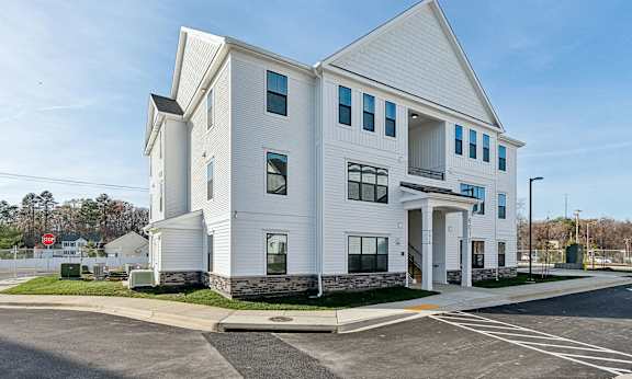 A white building with a parking lot in front.