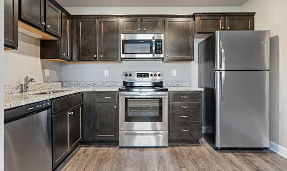 A modern kitchen with stainless steel appliances and wooden floors.