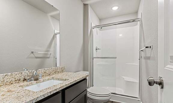 A bathroom with a sink, toilet, and shower.