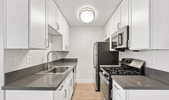 A kitchen with a white stove top oven and a white refrigerator.at Oak Park Apartments, California, 91016