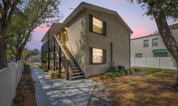 the exterior of a house with stairs and a sidewalk