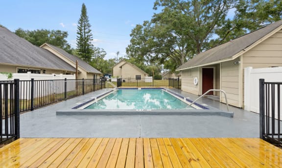 a swimming pool with a fence around it next to houses