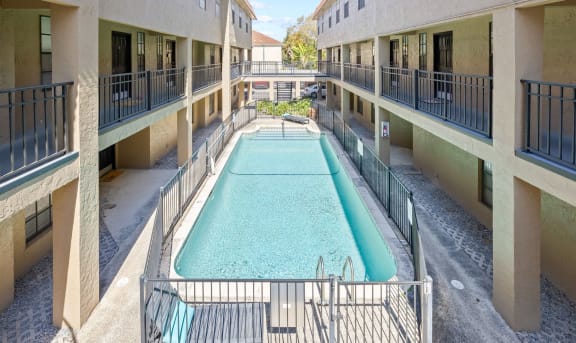 a pool in the middle of a building with buildings around it