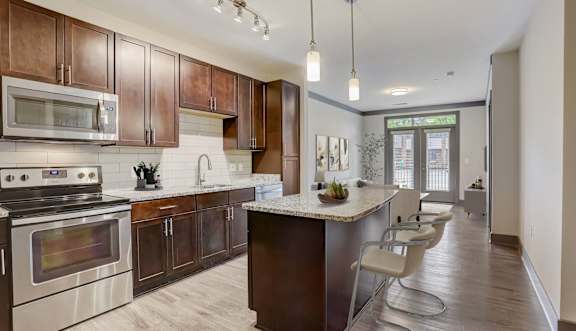 A modern kitchen with a center island and stainless steel appliances.