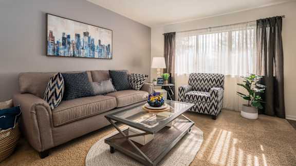 a living room with a couch and two chairs and a coffee table