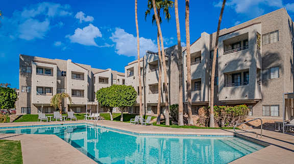 A swimming pool in front of apartment buildings.