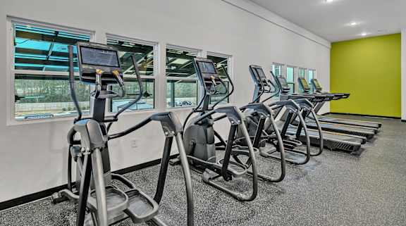 A gym with treadmills and elliptical machines.