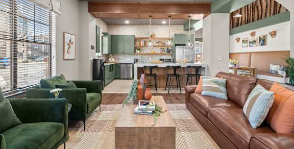 A living room with a green couch and a brown couch.