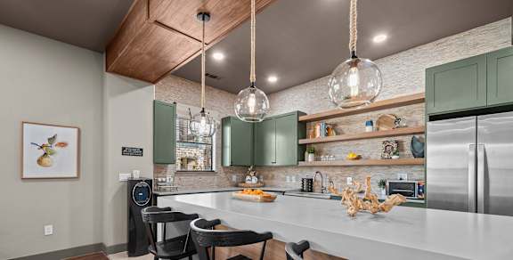 A kitchen with a white countertop and green cabinets.