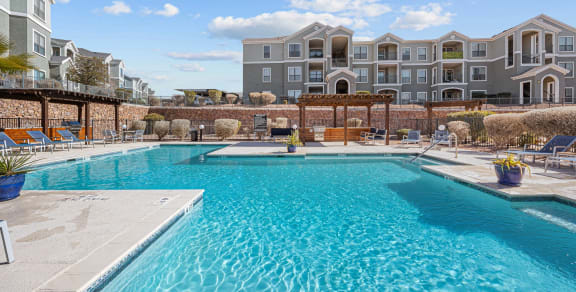 a swimming pool with an apartment building in the background