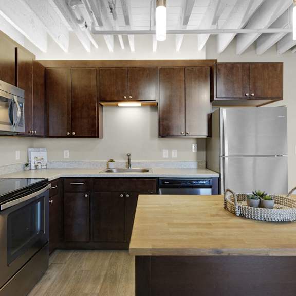 A kitchen with wooden cabinets and a refrigerator.
