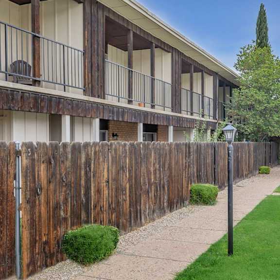 A wooden fence runs along the side of a building.