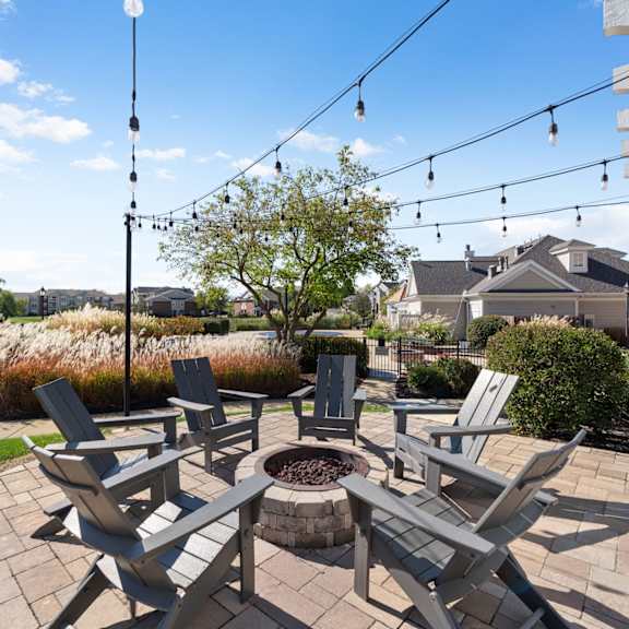 A patio with chairs and a fire pit.