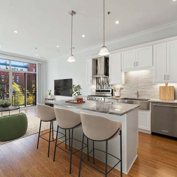 A modern kitchen with a large island and stainless steel appliances.