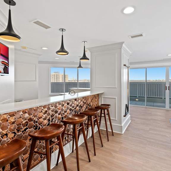 a bar with wooden stools in a room with a pool table