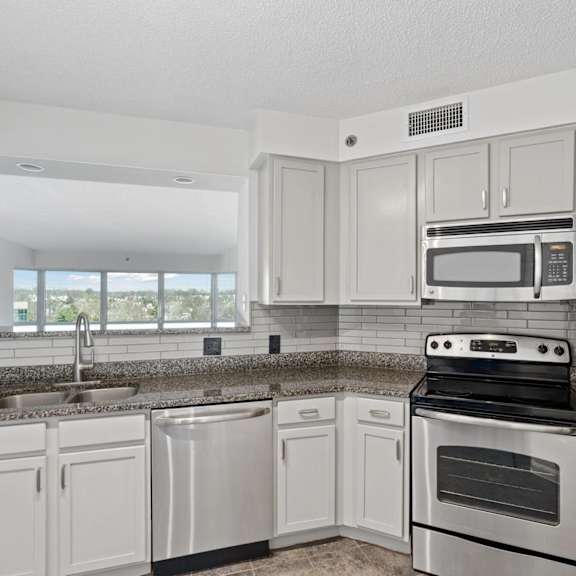 a kitchen with white cabinets and appliances and granite counter tops