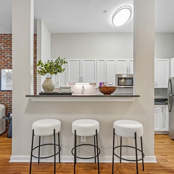 A kitchen with a bar and stools.